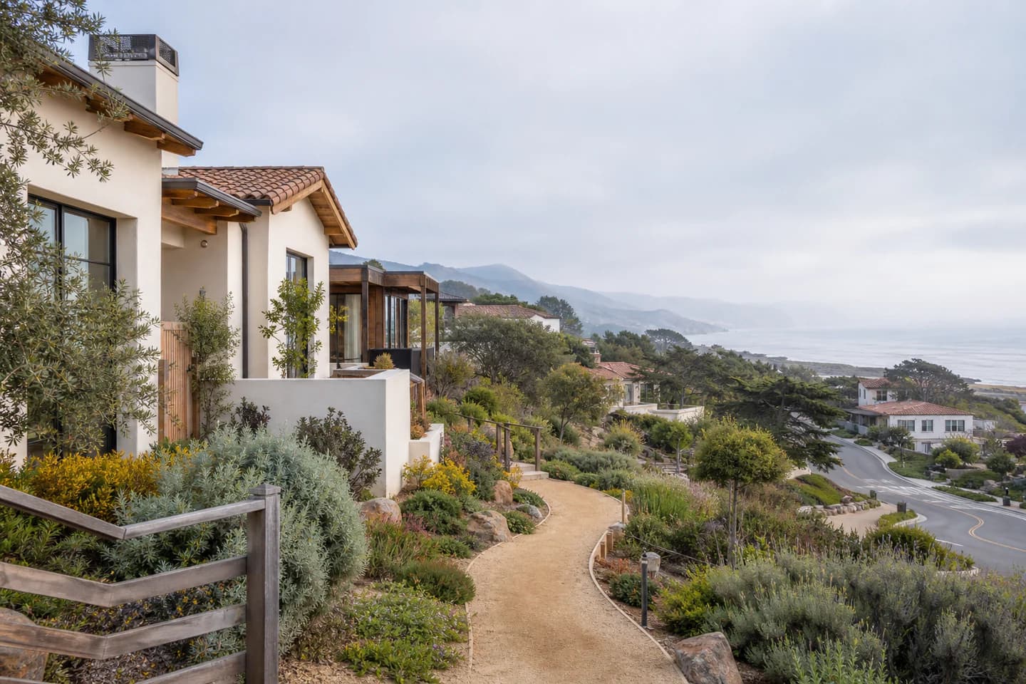 Editorial Central Coast residential context with coastal hillside homes, a planted path, and marine light; not an exact property or listing